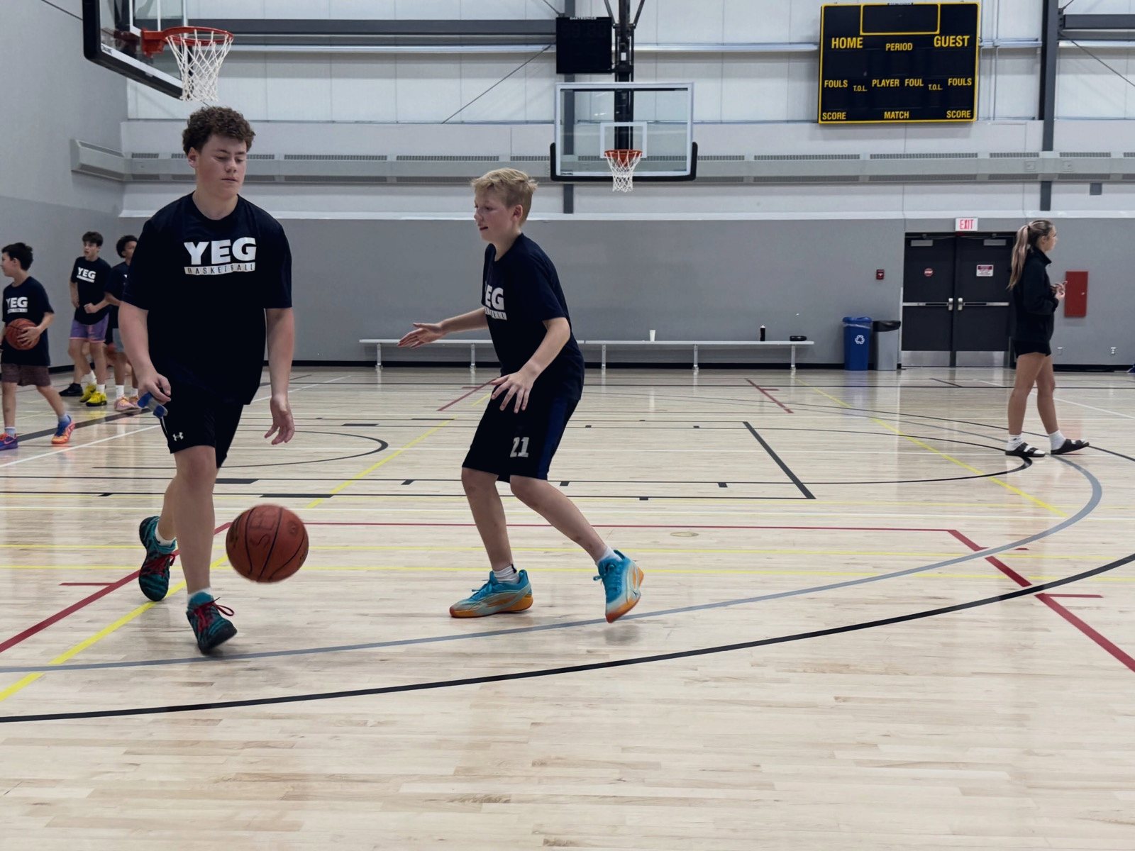 Two campers working on ball handling in the gym
