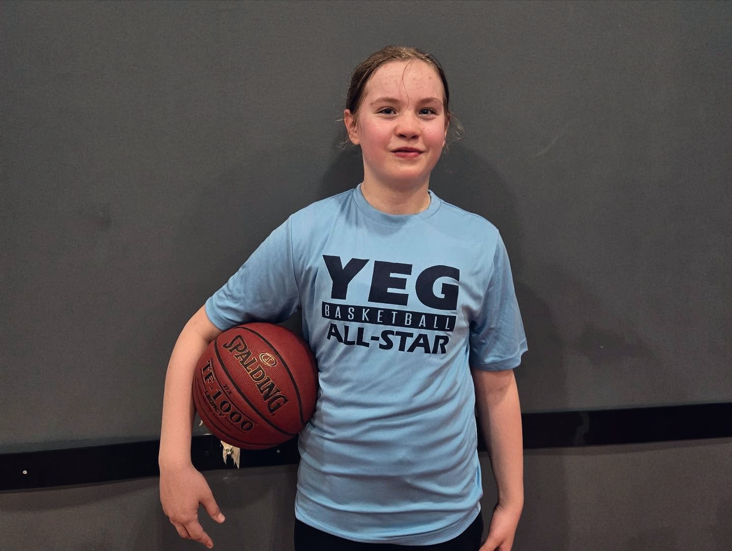 A YEG BASKETBALL Classic All-Star with her shirt and game ball